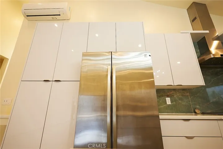 North side of custom kitchen w/ stainless refrigerator (included)