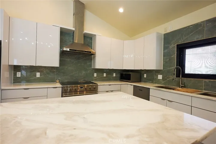 Over-sized range w/ custom hood w/ matching backsplash