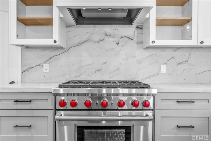 An enviable kitchen featuring top of the line Wolf appliances, Sub-Zero refrigerator, ample quartzite countertops, and gorgeous solid wood cabinetry.