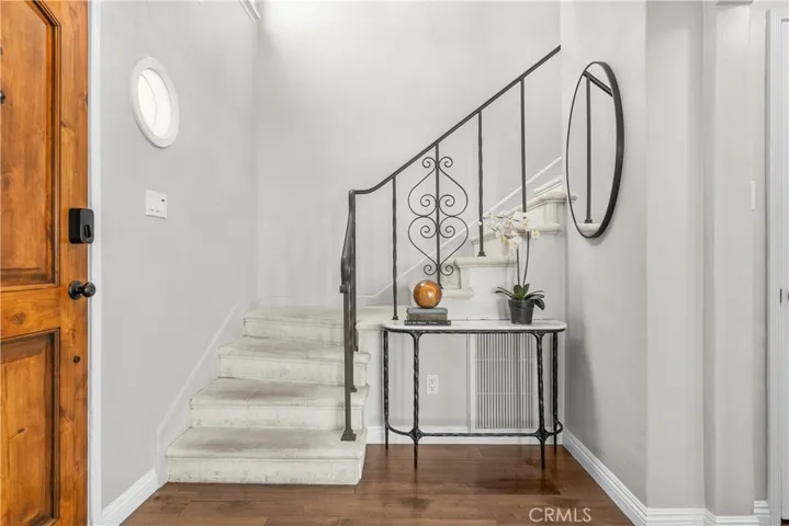 The entry of 6401 Corsini Pl and stairway to the upper level bedrooms.