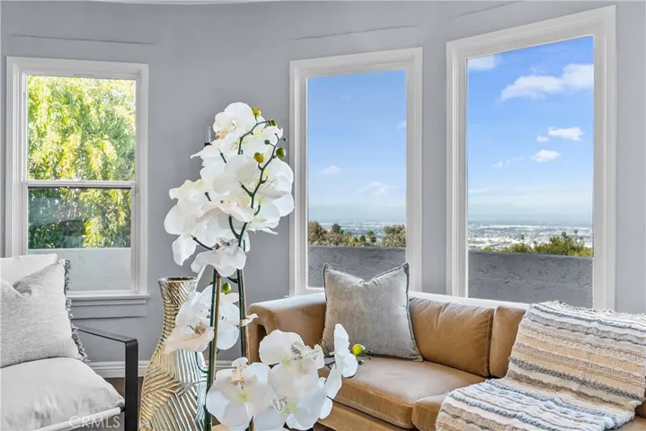 The living room is appointed with rich hardwood floors, an elegant stone fireplace, and subtle designer tones.