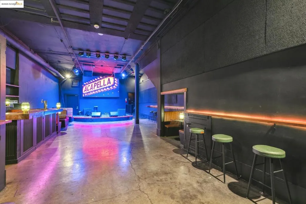 Rec room with a towering ceiling, concrete flooring, and a community bar
