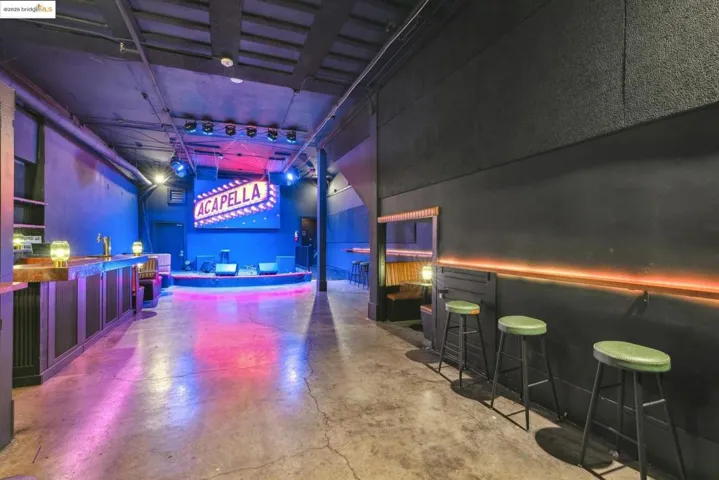 Rec room with a towering ceiling, concrete flooring, and a community bar