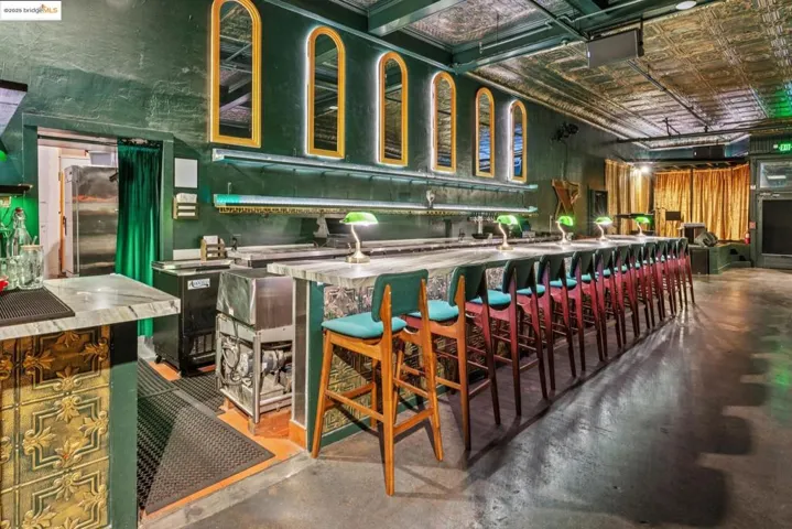 Bar with concrete floors, an ornate ceiling, stainless steel countertops, and green cabinets