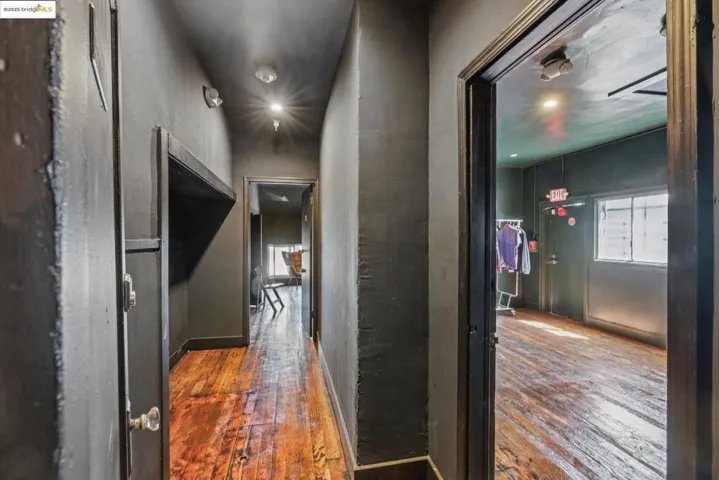 Corridor featuring dark wood-style floors and baseboards