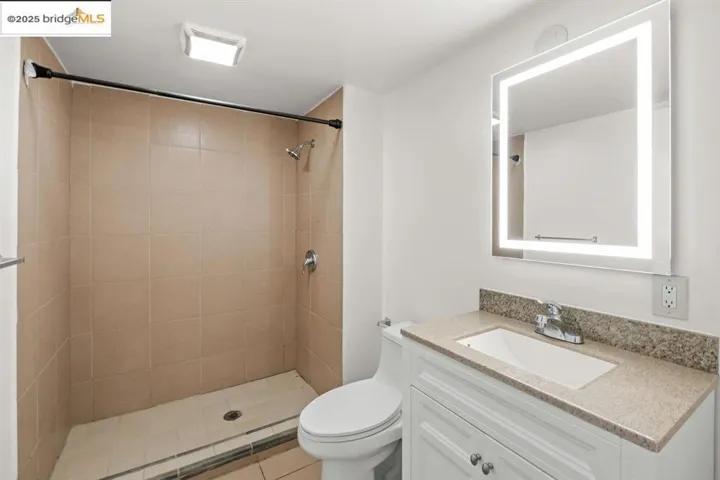 Full bathroom with vanity, a shower stall, and light tile patterned flooring