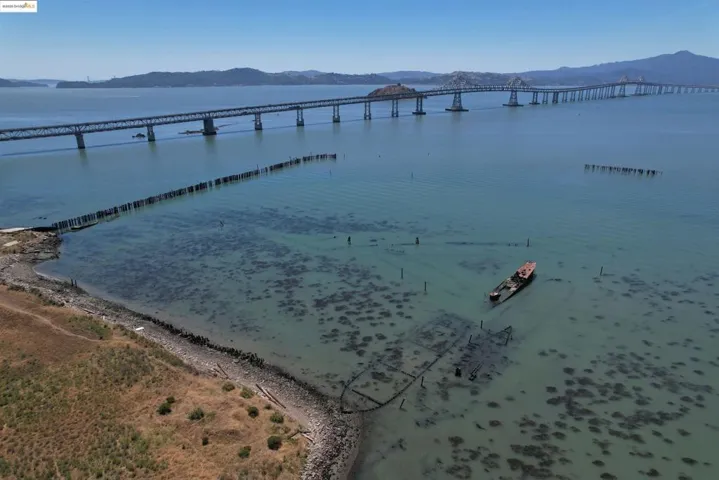 Water view featuring mountains and a notable bridge