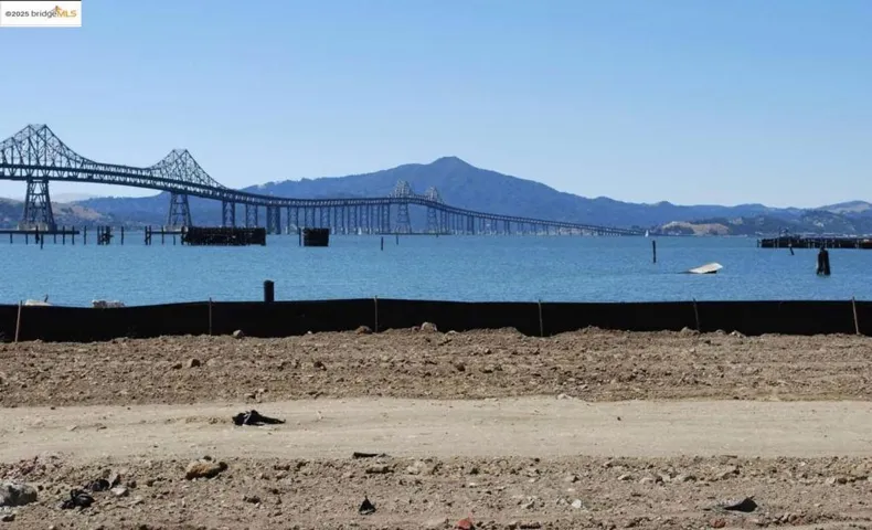 Water view featuring a mountain backdrop and a notable bridge
