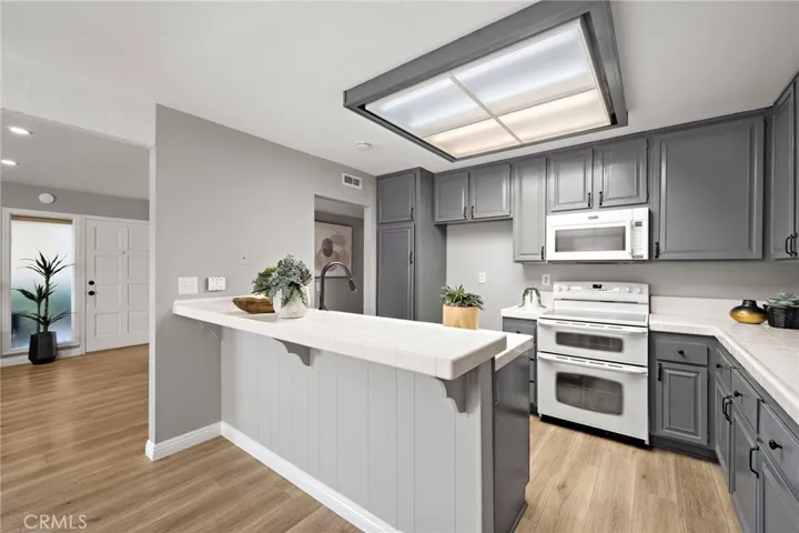 Remodeled Kitchen with Breakfast Bar Includes Repainted Cabinetry, Electric Range with Double Ovens, Microwave, and 2-Year-New Dishwasher