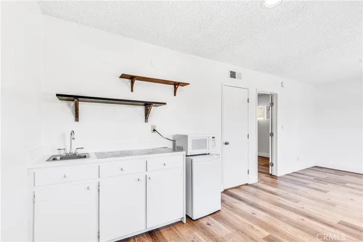 Kitchenette with microwave, sink and small refrigerator.
