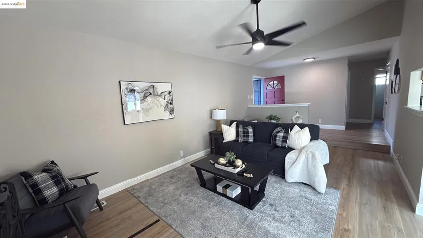 Living area with lofted ceiling, wood finished floors, and a ceiling fan