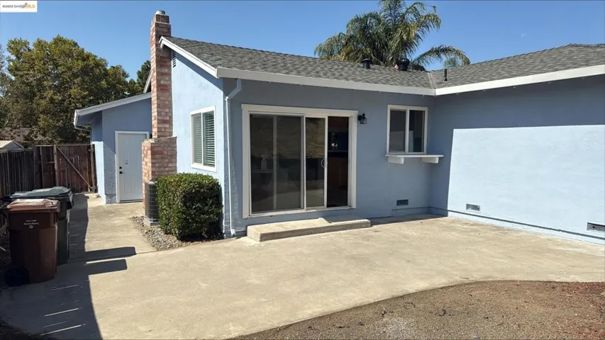 Back of house with stucco siding, crawl space, roof with shingles, a chimney, and a patio area