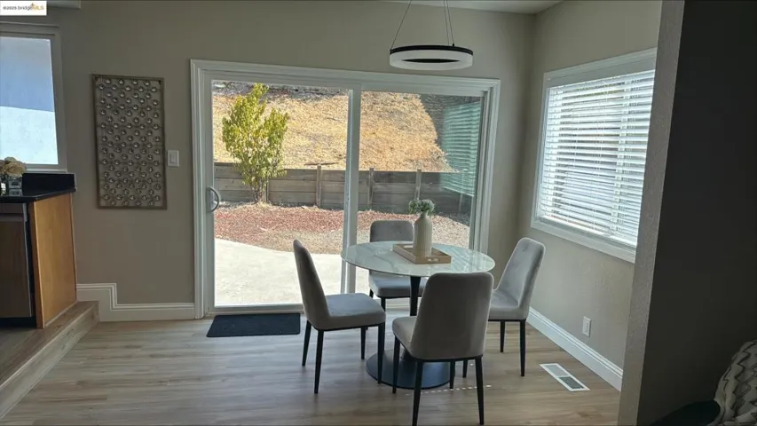 Dining room with light wood finished floors and healthy amount of natural light