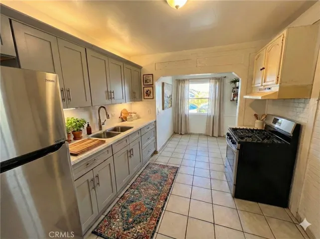 Front vacant unit kitchen and laundry area, virtually staged