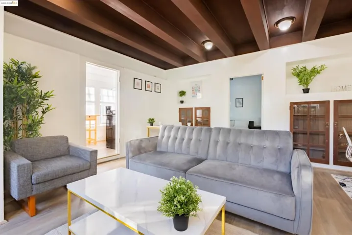 Living room featuring beam ceiling and wood finished floors