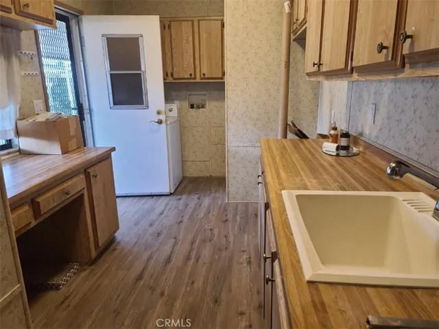 Utility/laundry room with vanity and deep sink.