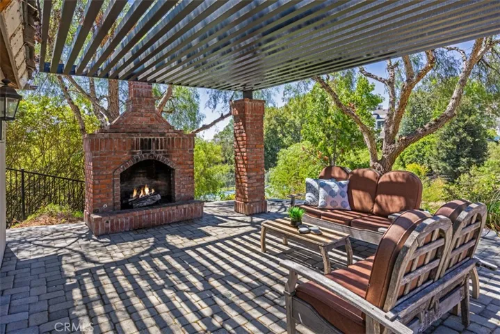 Covered gathering area near pool with fireplace