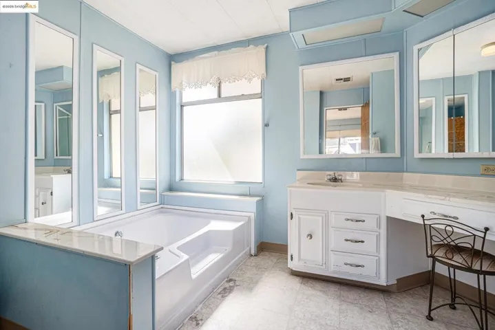 Full bathroom featuring vanity and a garden tub