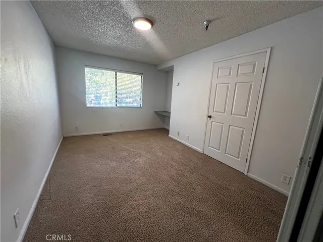 Bedroom with built-in desk and nice natural light from the window.