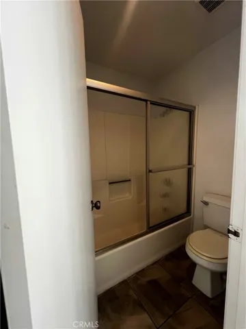 Bathroom with privacy door between vanity and toilet/shower tub area.