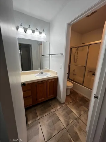 Bathroom with tile counters and shower/tub combo.