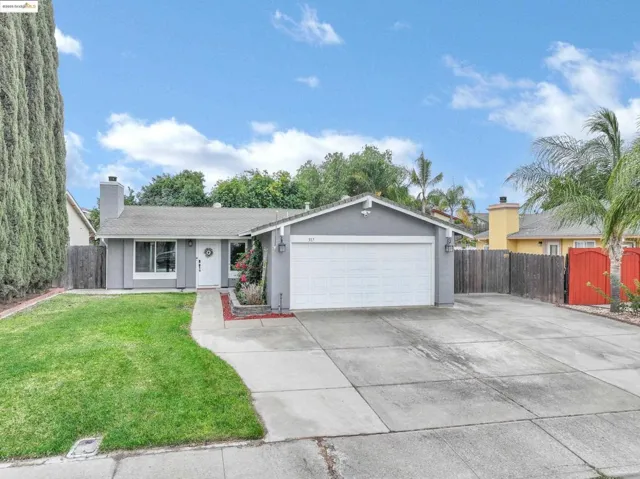 Single story home featuring driveway, stucco siding, a chimney, and an attached garage