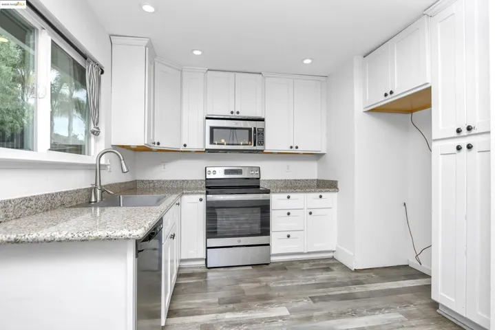 Kitchen featuring stainless steel appliances, white cabinets, light stone counters, and recessed​​‌​​​​‌​​‌‌​​‌​​​‌‌​​​‌​​‌‌​​‌‌​​‌‌​​​​ lighting