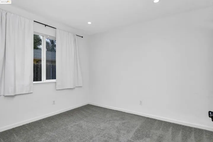 Carpeted empty room featuring recessed lighting