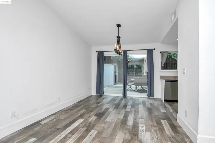 Unfurnished dining area with wood finished floors and vaulted ceiling