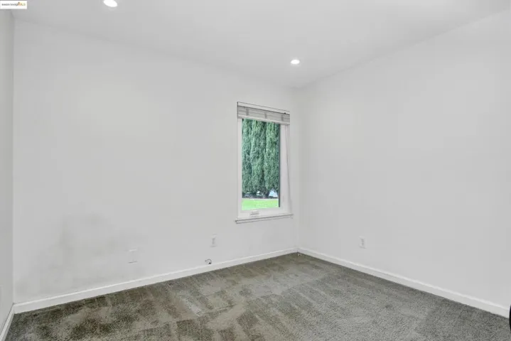 Carpeted spare room with baseboards and recessed lighting