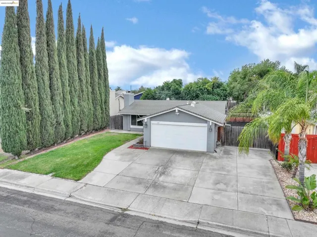 View of front of house with an attached garage, driveway, and stucco siding