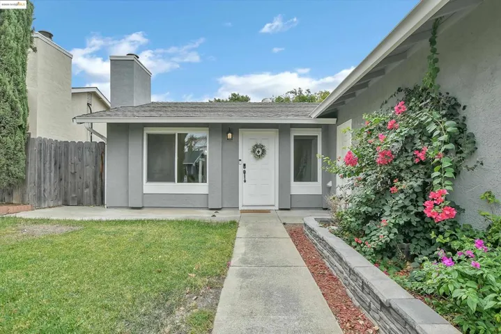 Doorway to property with stucco siding, a shingled roof, and a chimney