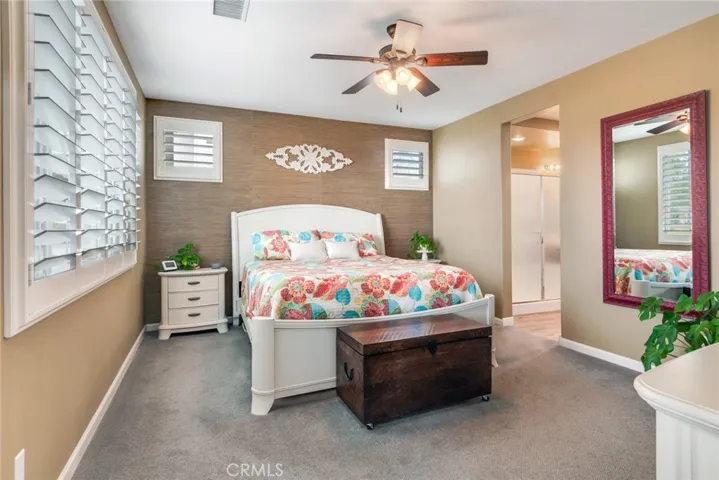 Spacious, carpeted, Primary Bedroom, Upgraded With Plantation Shutters & Fan-Light To Control Both Temperature & Atmosphere