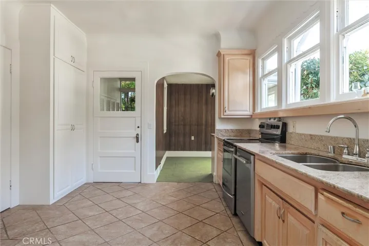 Kitchen with arched doorway to a breakfast nook.