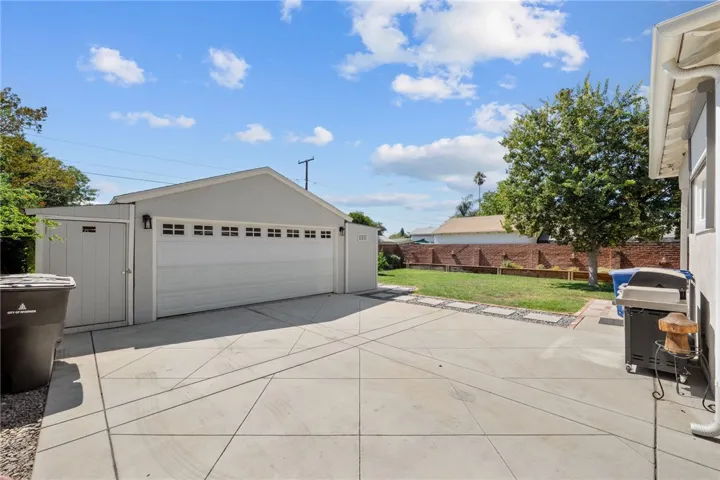 Detached garage with tasteful sheds on the sides for extra storage