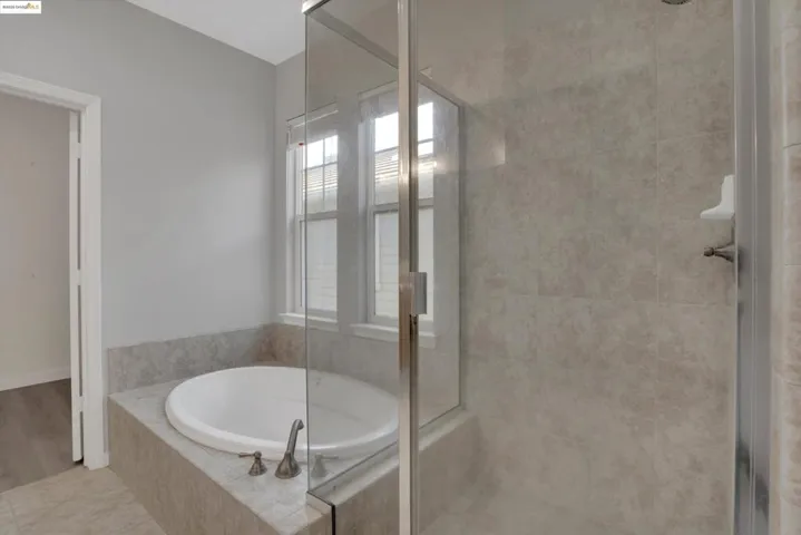 Full bath with a shower stall, a garden tub, and tile patterned floors