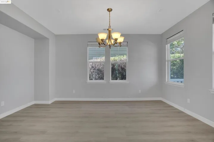 Unfurnished dining area featuring a chandelier and light wood-type flooring