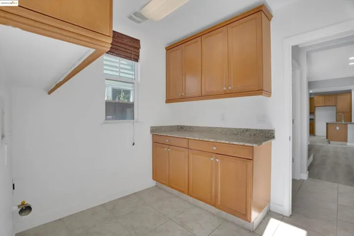 Laundry room with light tile patterned floors and baseboards