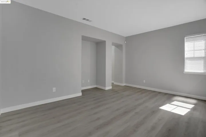 Spare room featuring light wood-style flooring and baseboards
