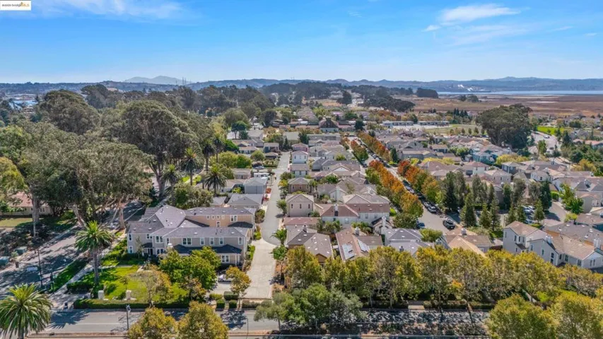 Aerial view of property and surrounding area featuring mountains and nearby suburban area