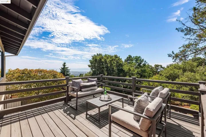 Wooden terrace featuring an outdoor living space and view of wooded area