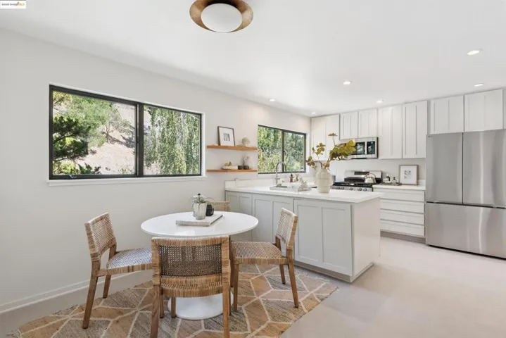Kitchen featuring white cabinets, appliances with stainless steel finishes, light colored carpet, recessed lighting, and open shelves