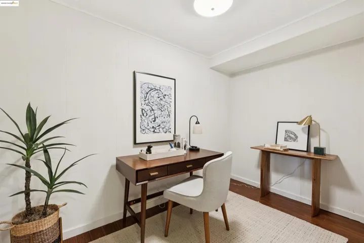 Office with dark wood-type flooring and baseboards