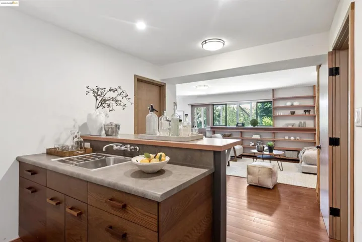 Kitchen with wood finished floors, a peninsula, light countertops, brown cabinets, and open floor plan