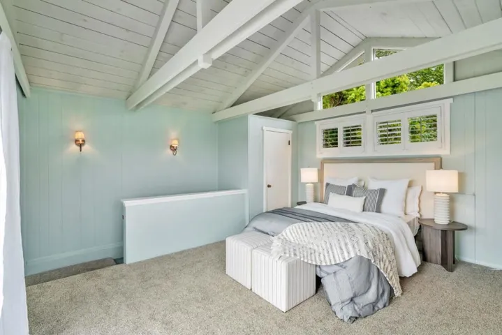 Primary bedroom with vaulted ceilings looking at staircase