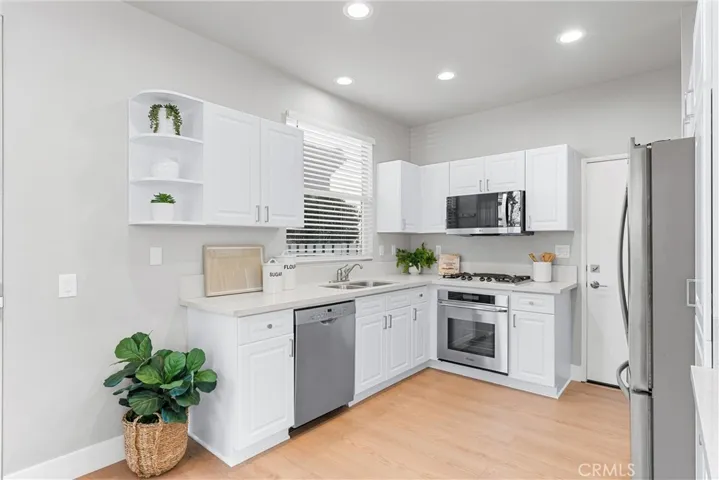 Crisp white cabinets, stainless steel appliances, Quartz Counters