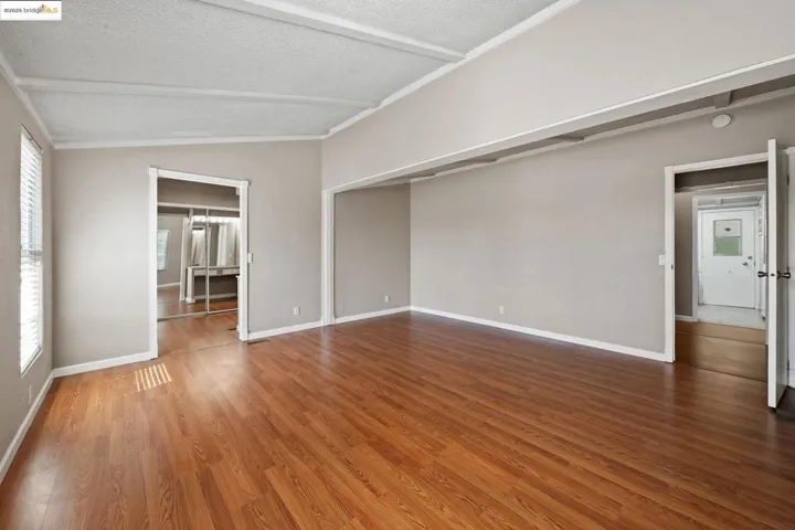 Empty room with dark wood finished floors and a textured ceiling