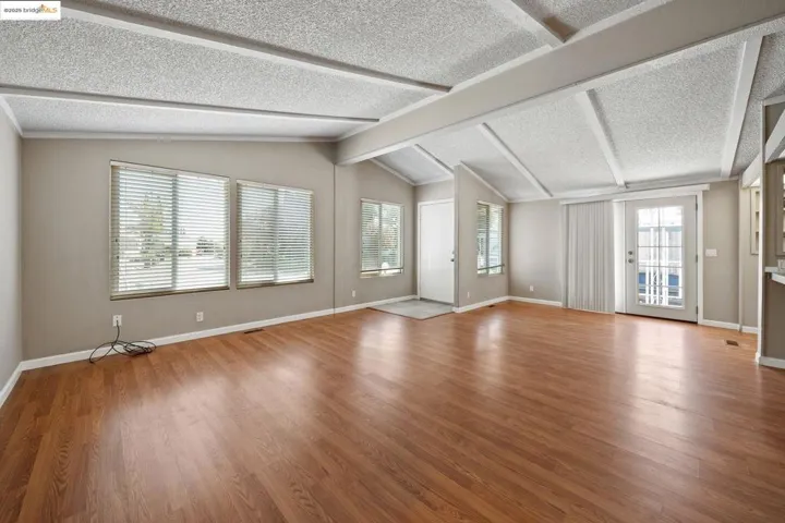 Unfurnished living room with light wood-style floors and a textured ceiling