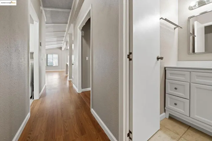 Hall with a textured wall and light wood finished floors