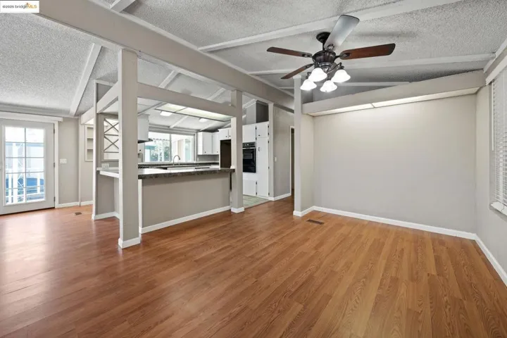 Unfurnished living room with light wood-style floors, a ceiling fan, and a textured ceiling